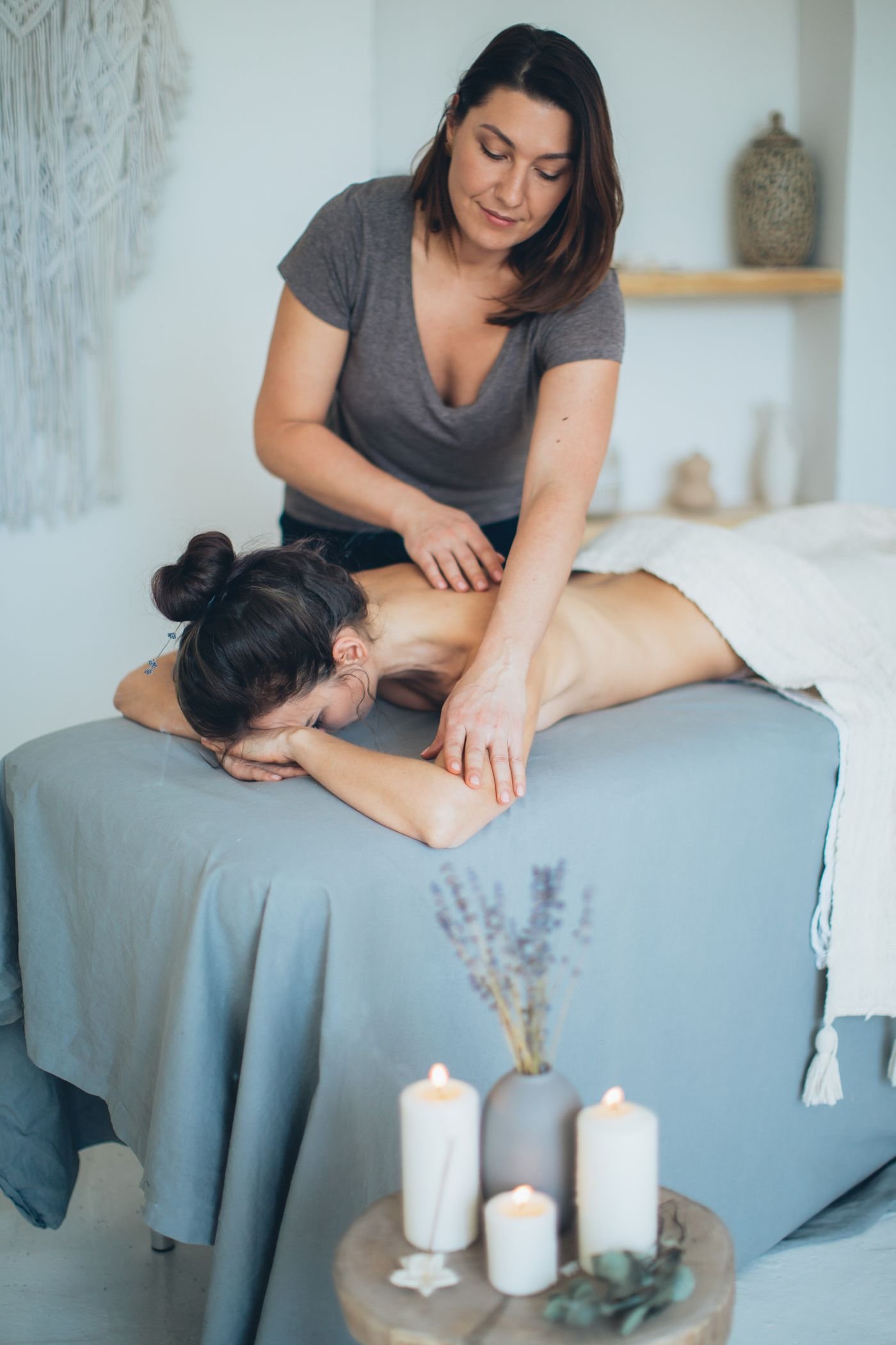 Massage therapist providing a treatment in a calm, softly lit room