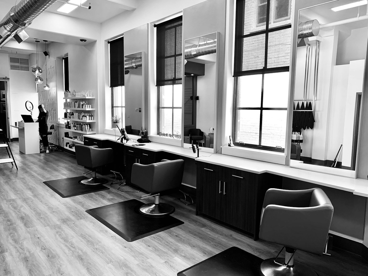 Salon interior with black styling chairs and a rustic wood floor